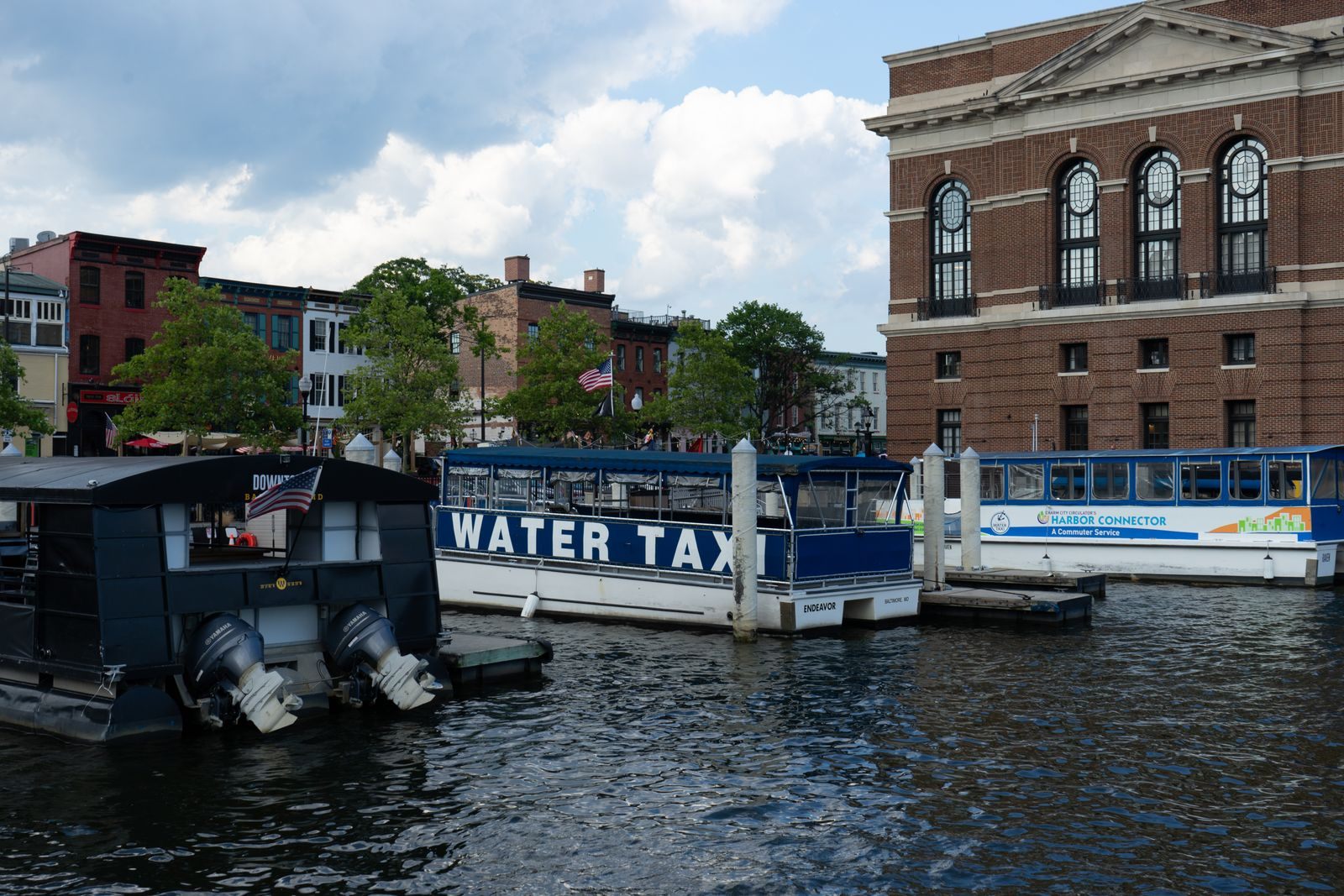 Water taxis and historic buildings on the Baltimore harbor waterfront, home of cruises from Baltimore