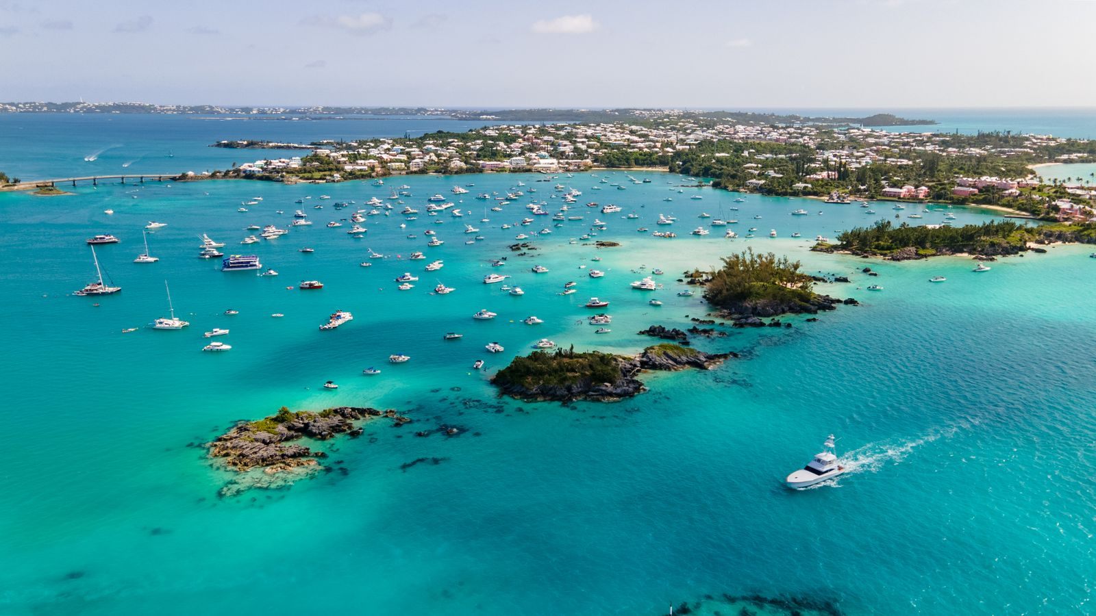 Boats on turquoise water in a Bermuda harbor, the goal of cruises from New York to Bermuda