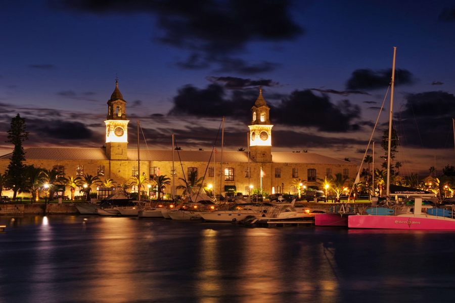 Royal Naval Dockyard in Bermuda lit up at night with its clock towers