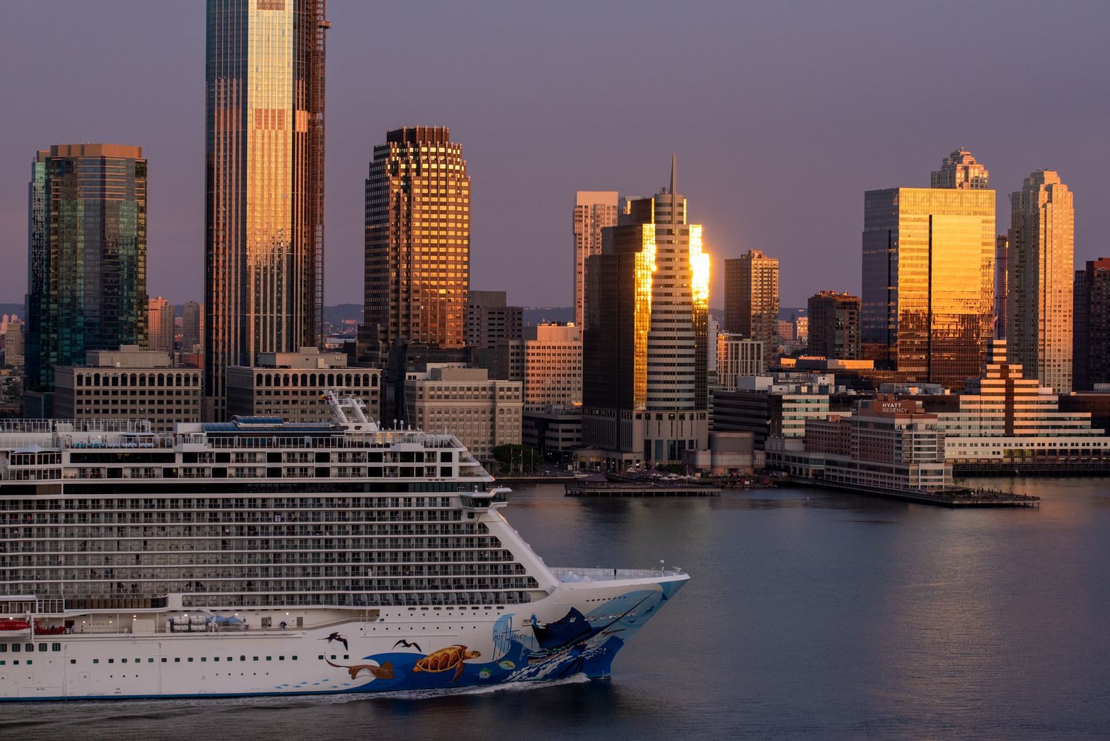Cruise ship passing the New York City skyline at sunset, a drive-to way to cruise for less