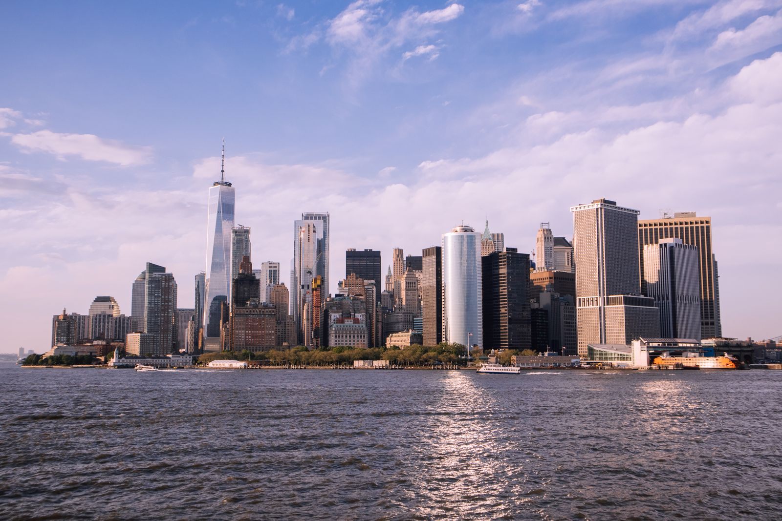 Lower Manhattan skyline across the harbor on a clear day, the backdrop for cruises from New York